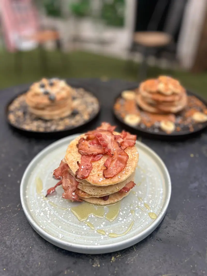 Stack of pancakes with crispy bacon and syrup