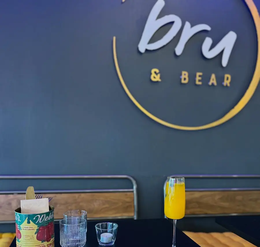 The Bru & Bear logo on the café wall above a table