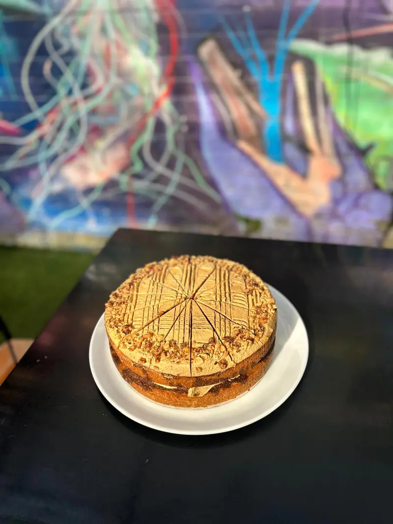 Layer cake topped with chopped nuts, cut into slices
